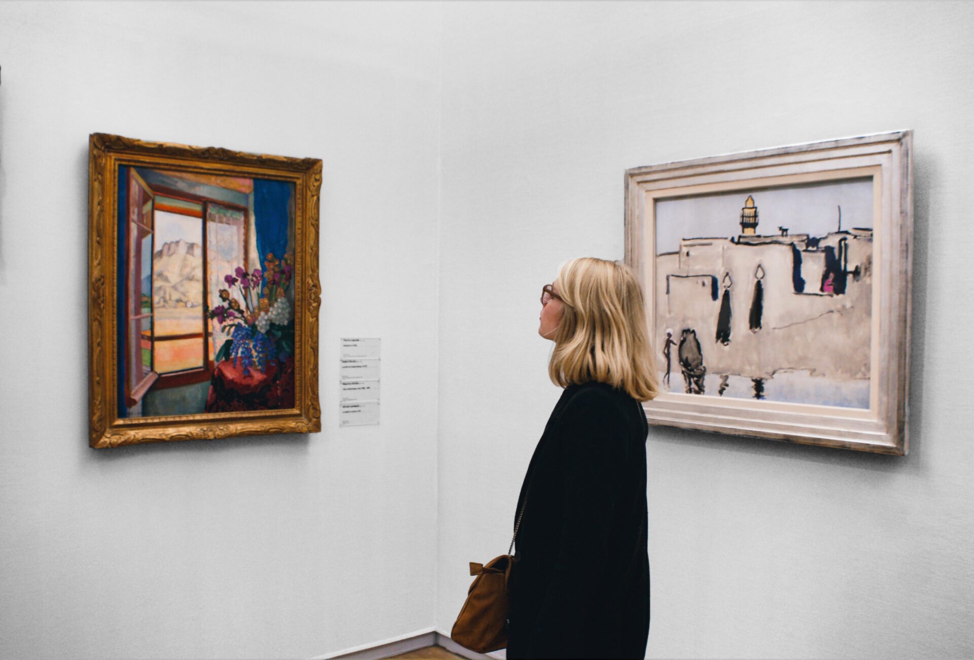 Nainen katsoo maalausta taidenäyttelyssä.
